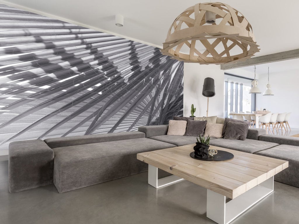 Wohnzimmer mit großformatiger Fototapete eines Palmenblatts